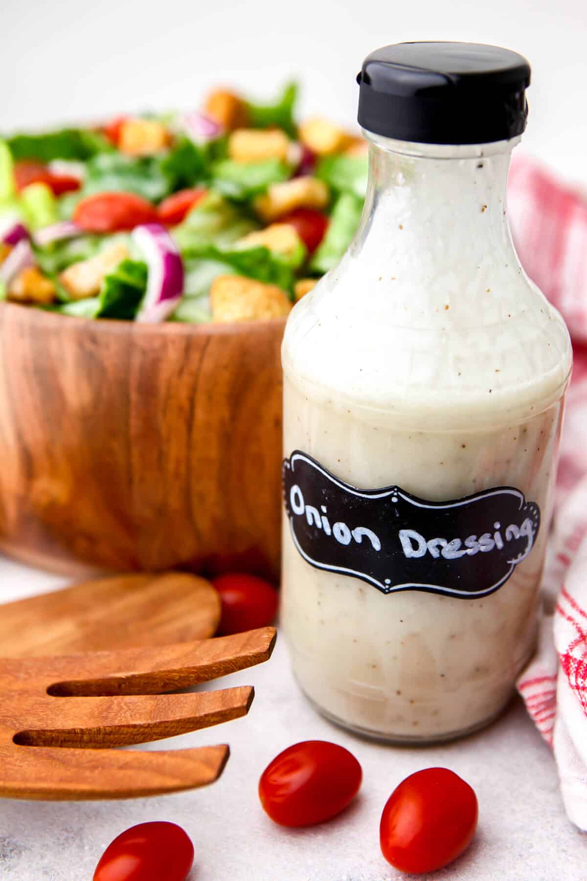 A bottle of Vidalia onion dressing in front of a green salad.