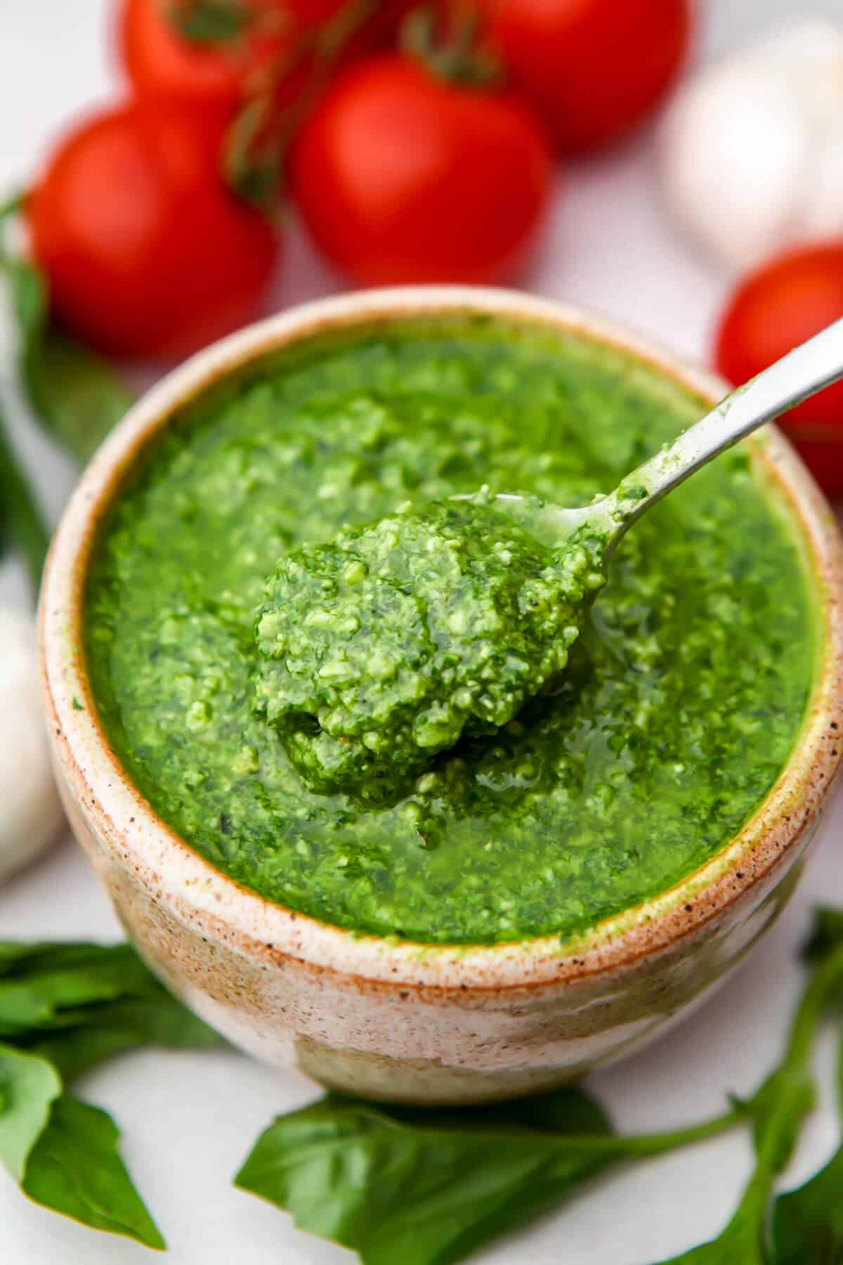 A bowl of vegan pesto with a spoon scooping some up.