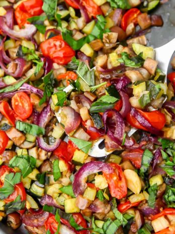 Mediterranean roasted eggplant with vegetables on a sheet pan.