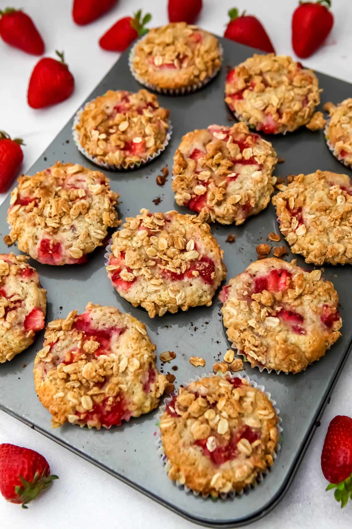 Baked vegan strawberry muffins in a muffin tin.
