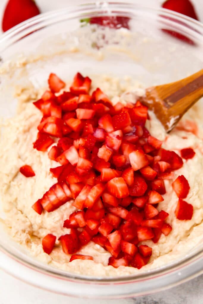 Adding chopped strawberries to the muffin batter.