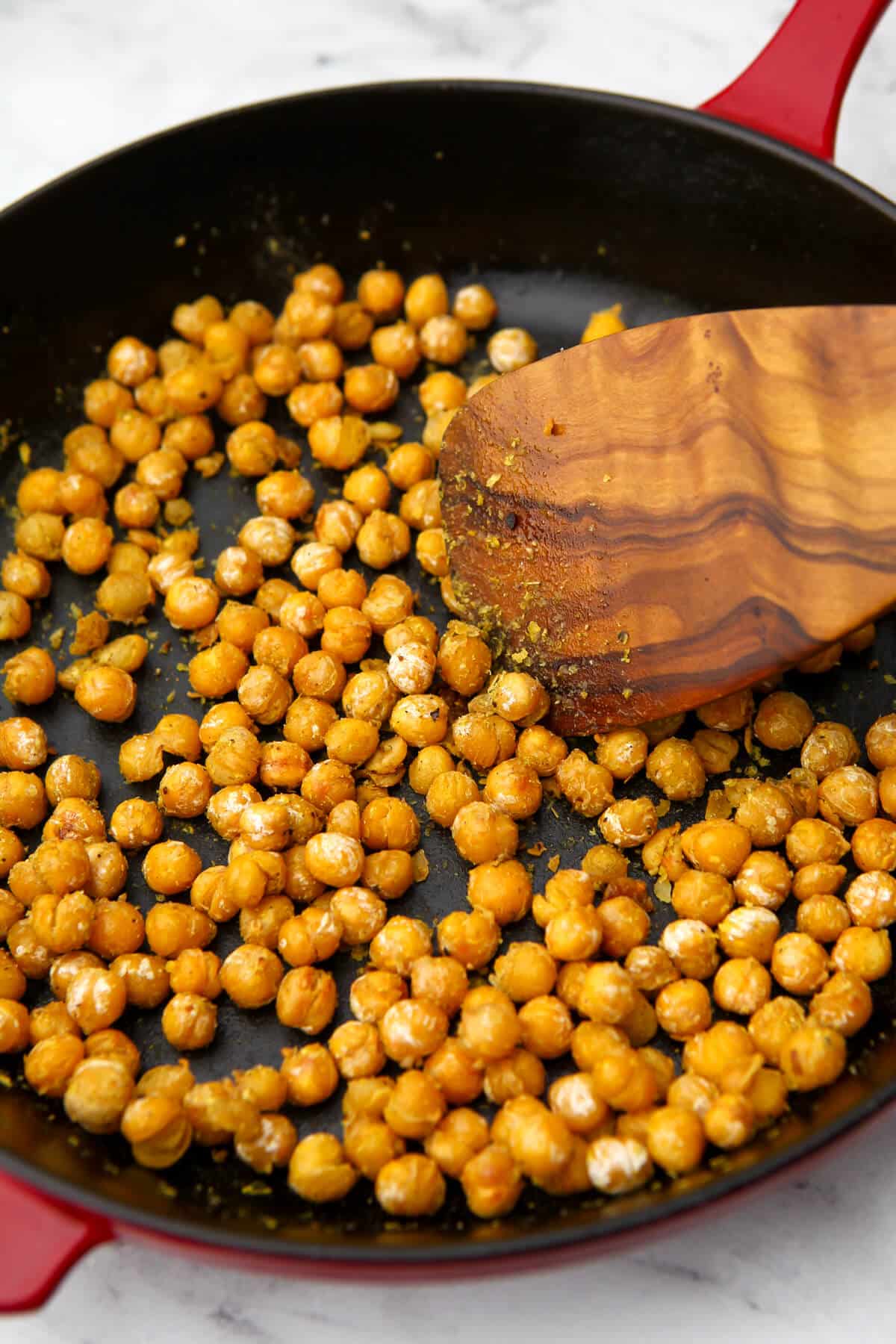 Seasoned sauteed chickpeas in an iron skillet after cooking.