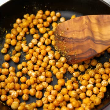 A close up of sauteed chickpeas with seasoning on them.