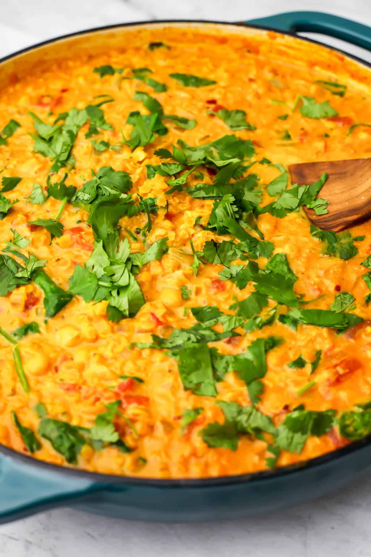 A blue skillet filled with vegan chickpea red lentil curry.