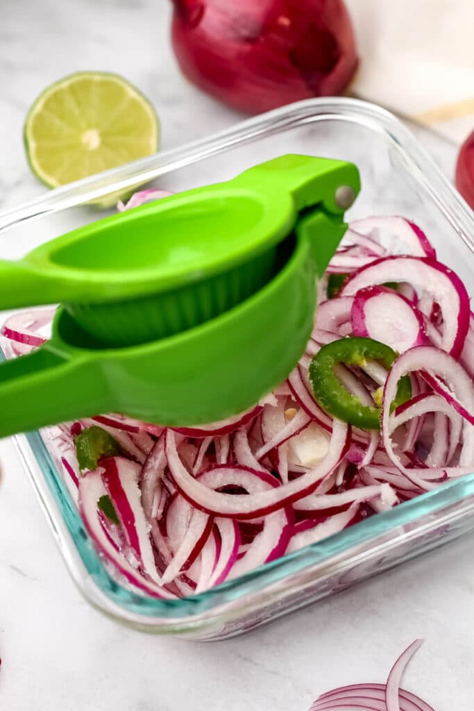 Squeezing lime juice on the sliced red onions.