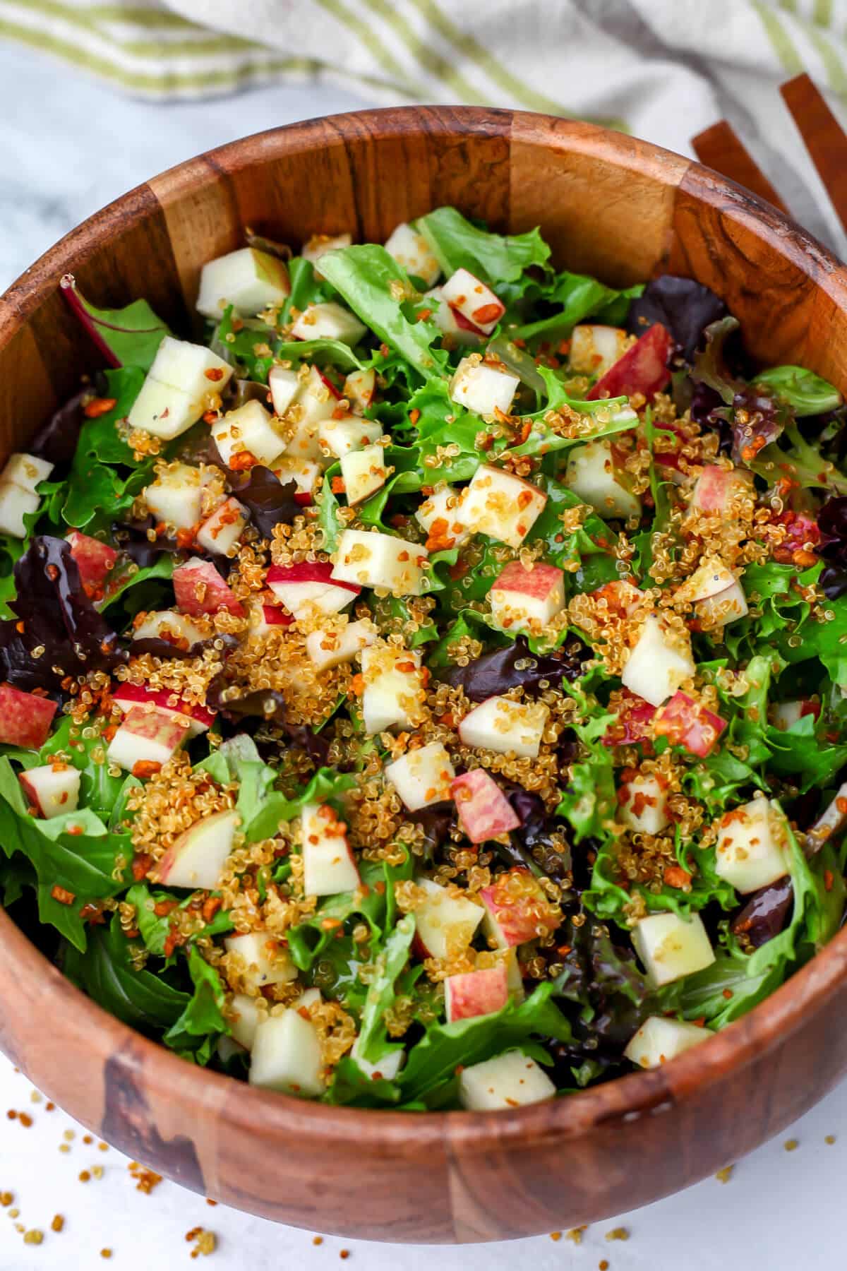 A vegan apple salad with crunchy quinoa sprinkled on top.