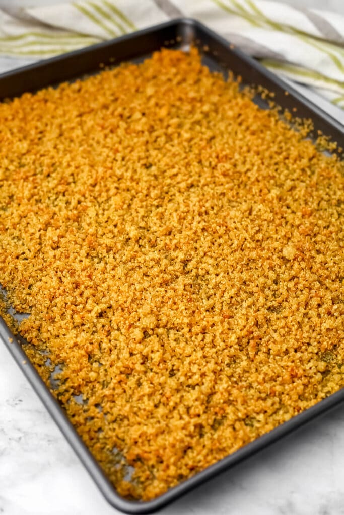 Quinoa on a baking sheet after it has been baked to a golden brown.