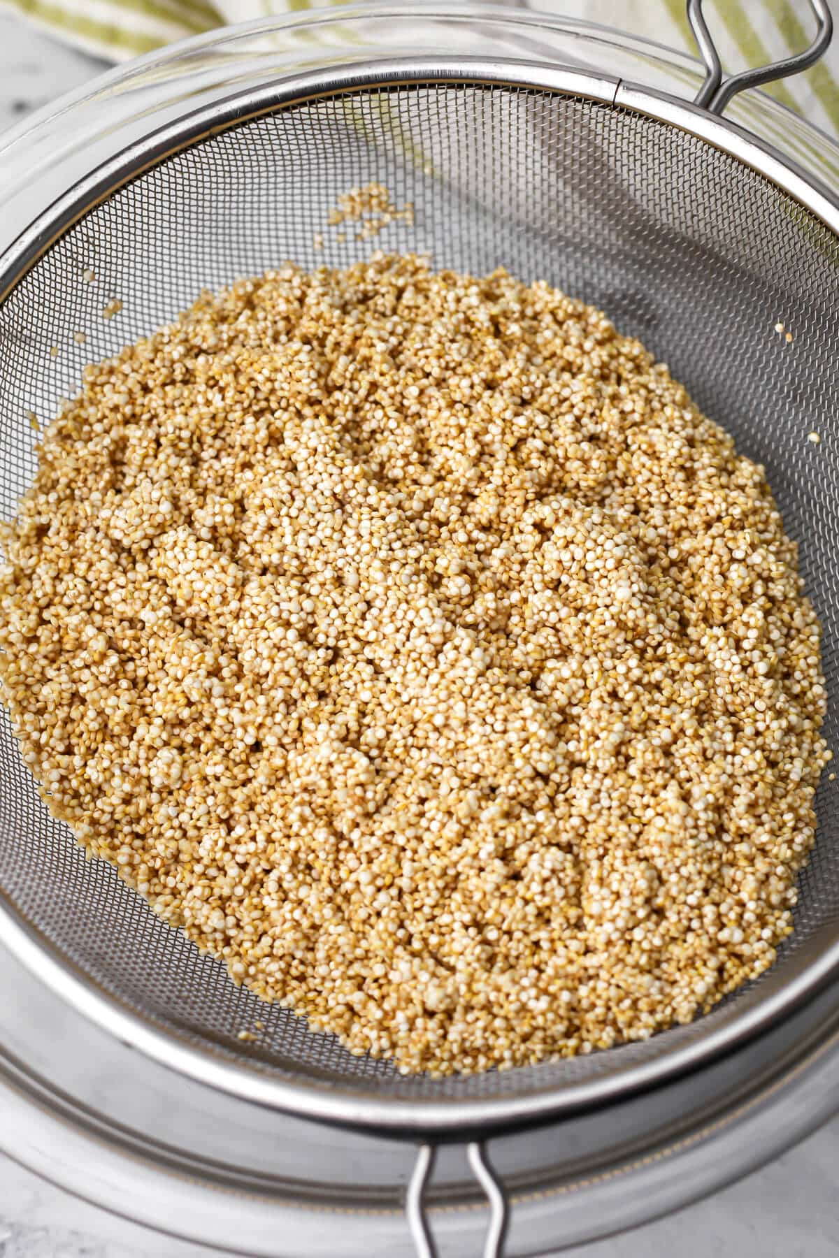 Quinoa that has been washed in a mesh colander.