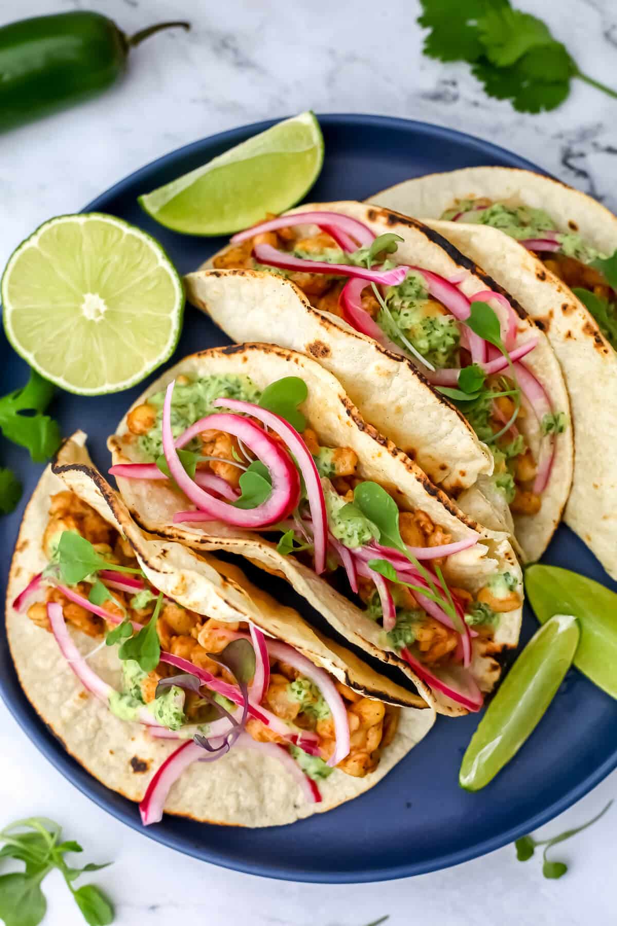 Tempeh tacos with pickled Mexican onions and vegan cilantro live crema on them.