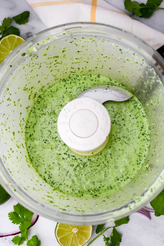 Blended cilantro lime crema in a food processor.