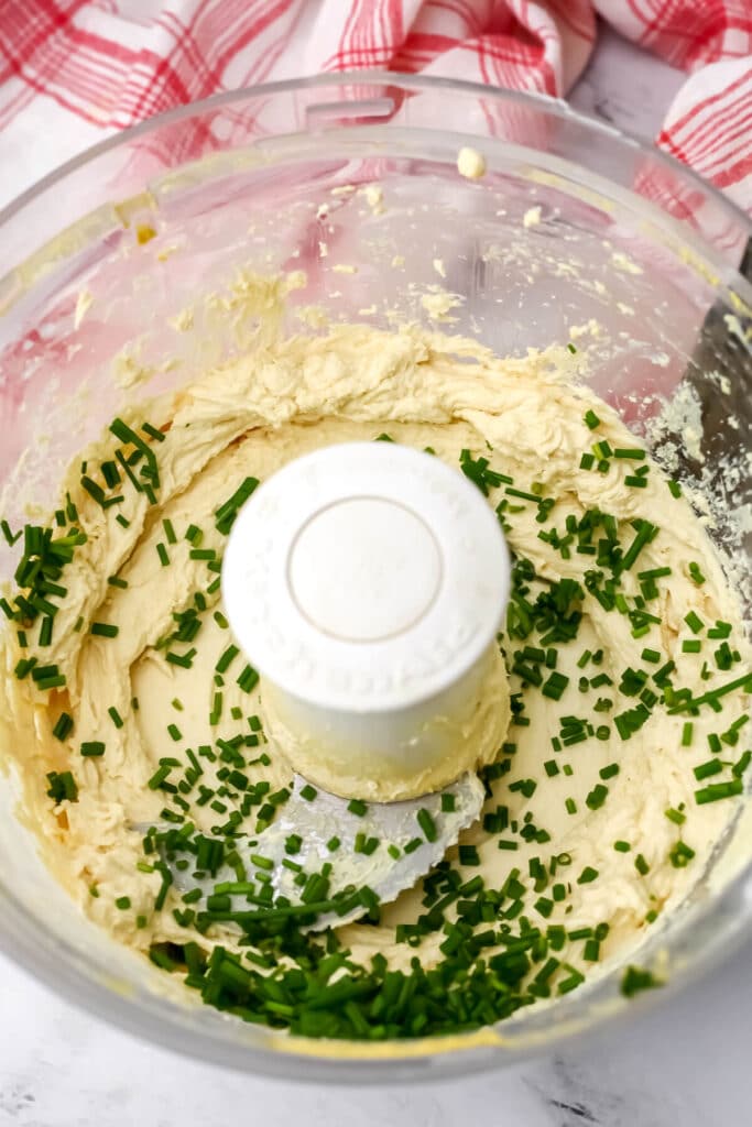 Chopped chives added to the tofu mixture in a food processor to make a vegan cheese ball.