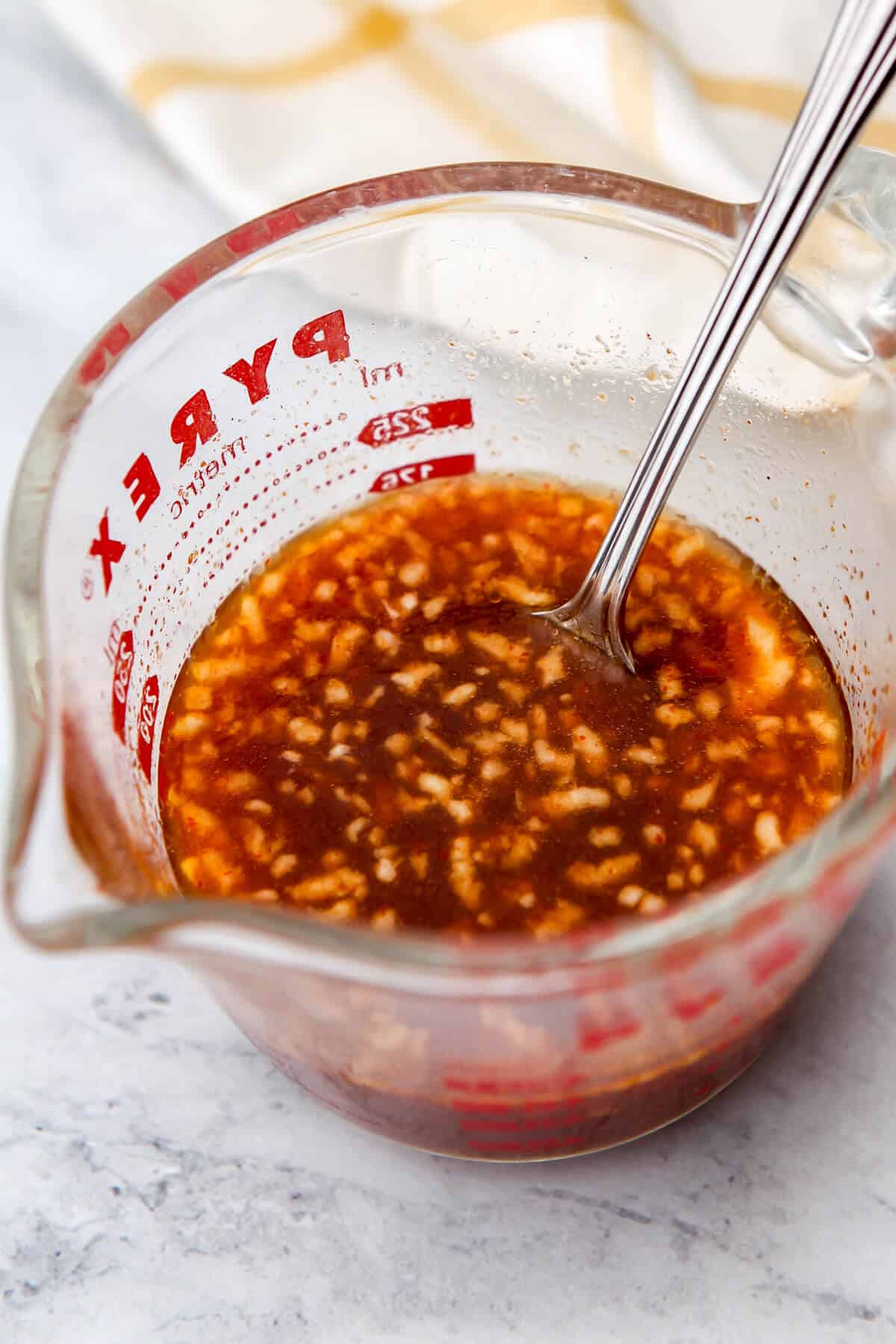 Vegan stir-fry sauce mixed up in a glass Pyrex measuring cup.
