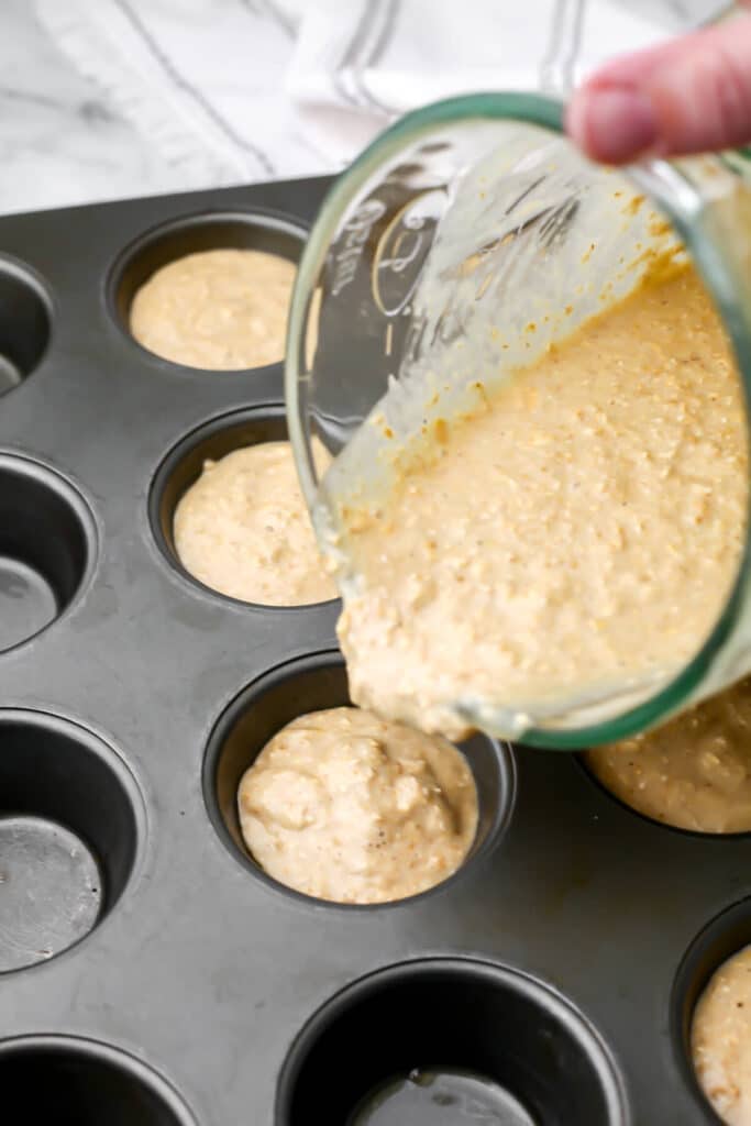 Pouring the oatmeal batter into a muffin tin.