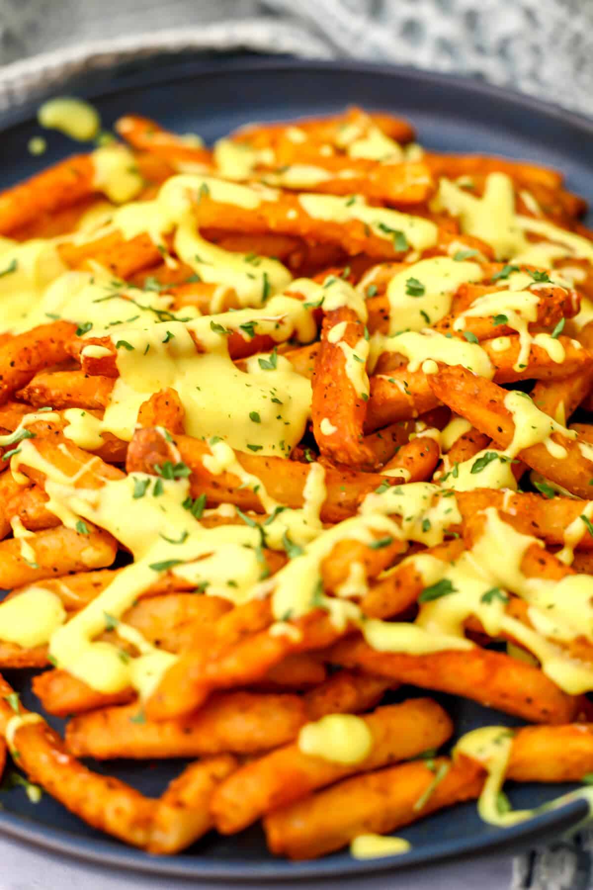 Vegan cheese sauce poured over French fries.