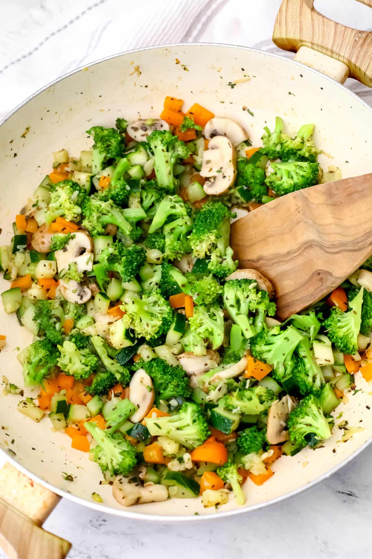 Sautéed veggies in a wok being cooked to make creamy veggie pasta.