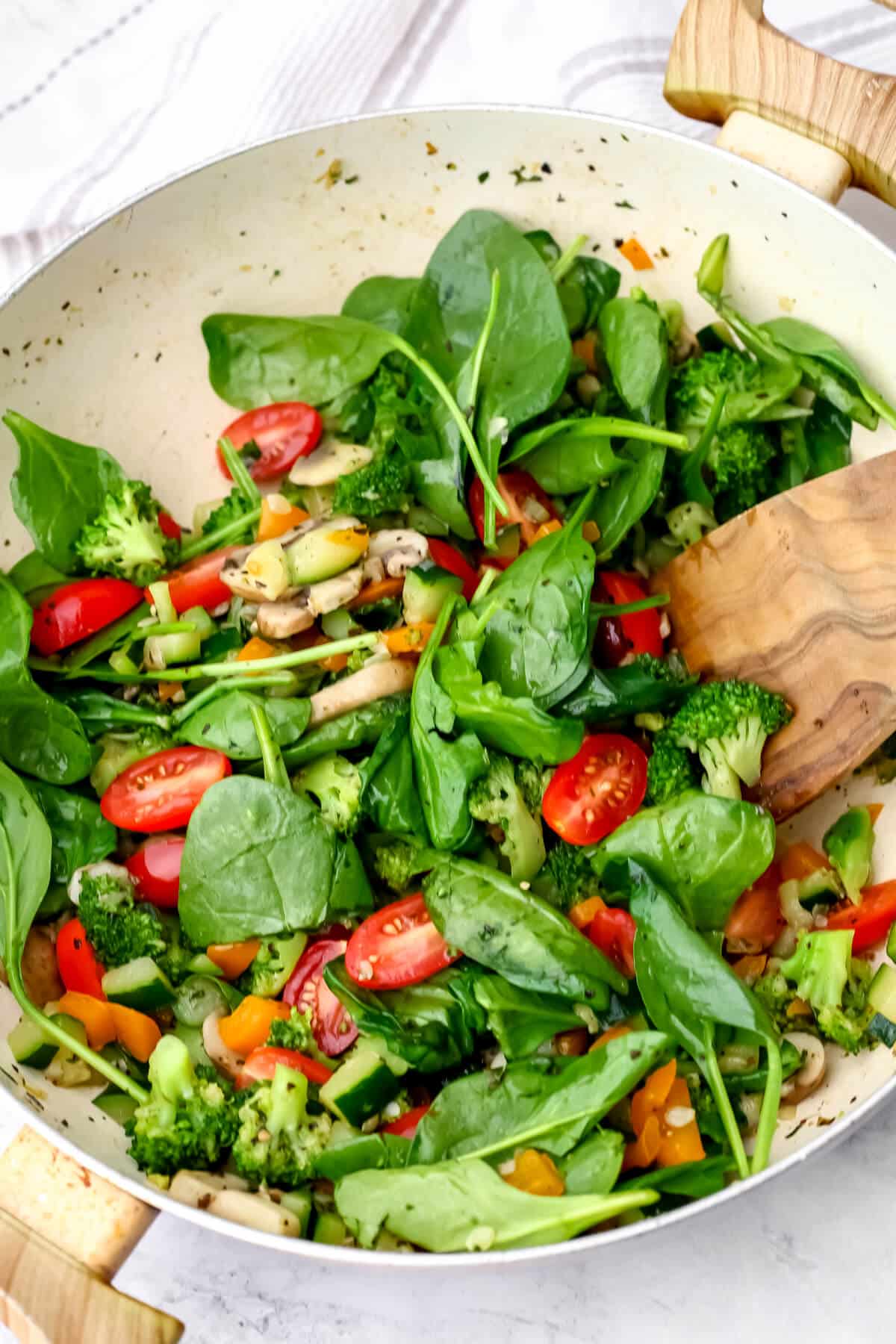 Spinach and cherry tomatoes added to sautéed veggies.