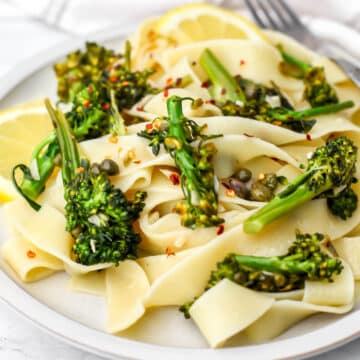 A with plate with broccolini pasta sauce with capers and lemon.