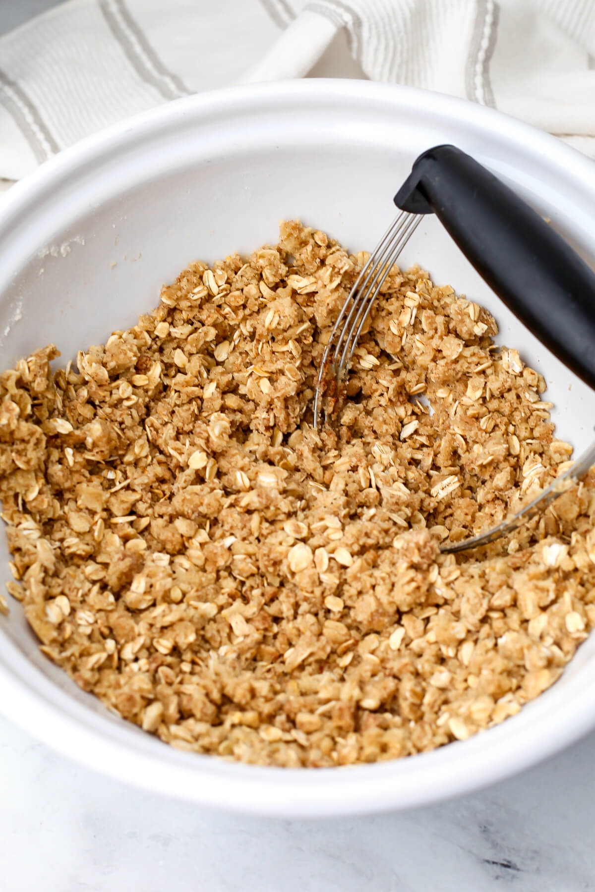 A bowl filled with brown sugar and oat crumble to make crumb bars.