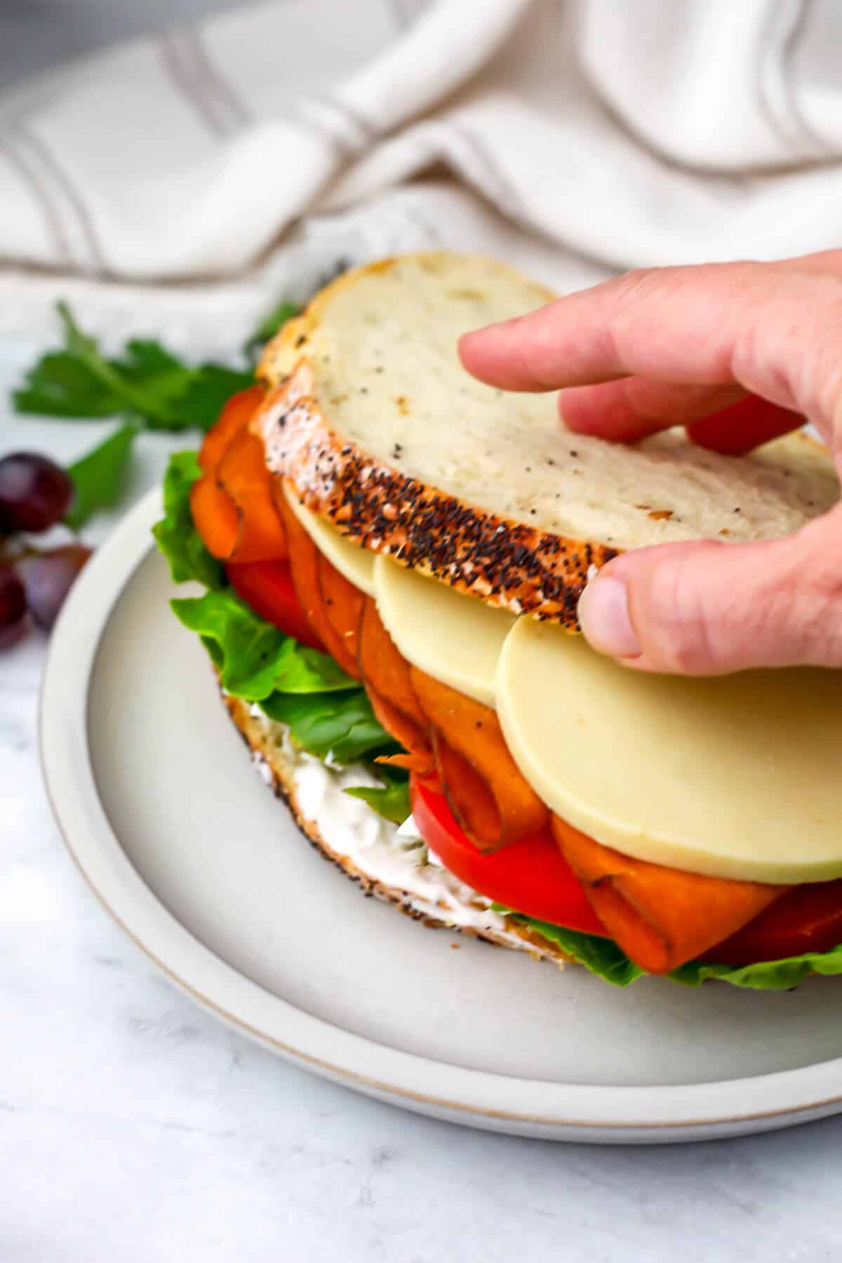 Someone making a vegan sandwich with vegan cheese slices.