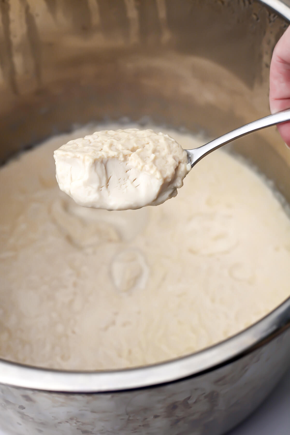 Vegan Greek yogurt being spooned out of an instant pot.