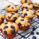 Blueberry Applesauce muffins on a black wire cooling wrack.