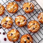 A top view of vegan cranberry orange muffins with lemon glaze.