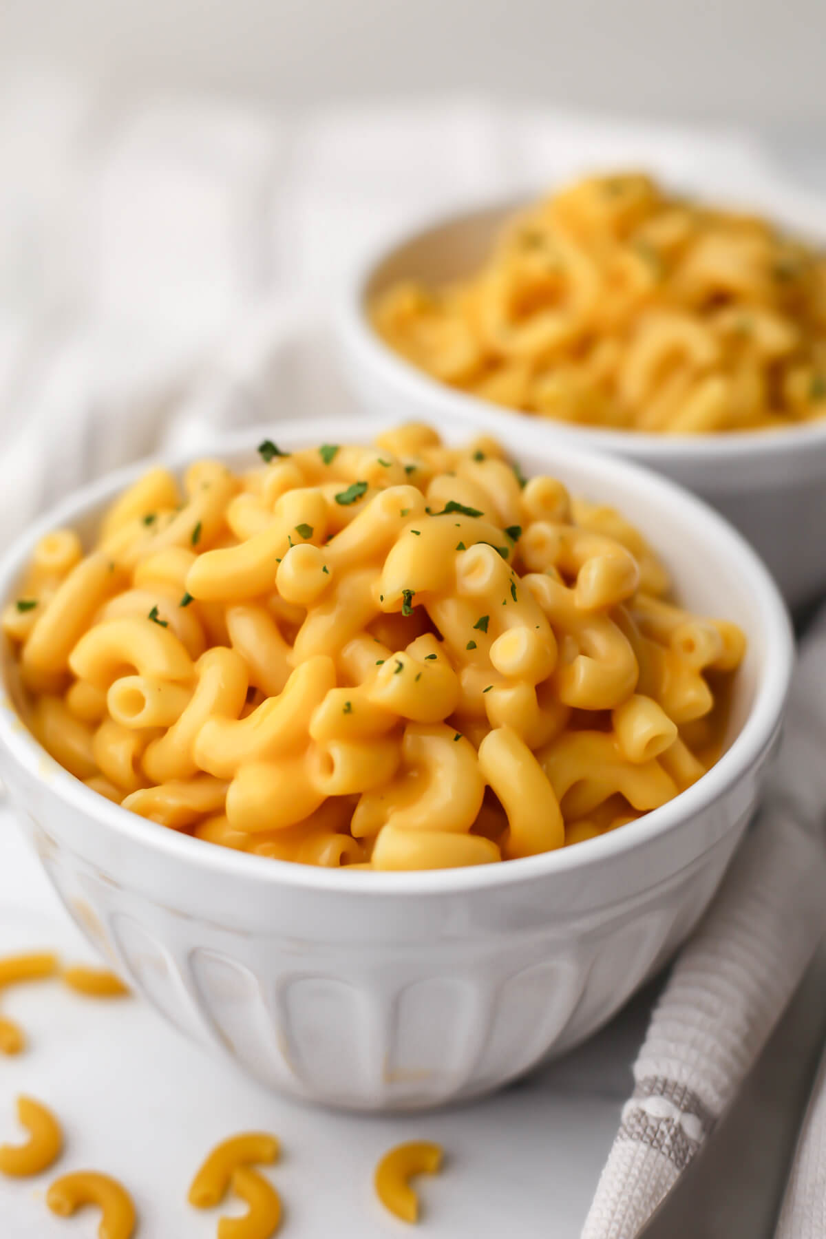 Two white bowls filled with easy vegan mac and cheese made without nutritional yeast.