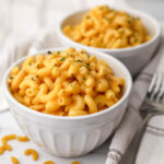 Two white bowls filled with easy vegan mac and cheese made without nutritional yeast.