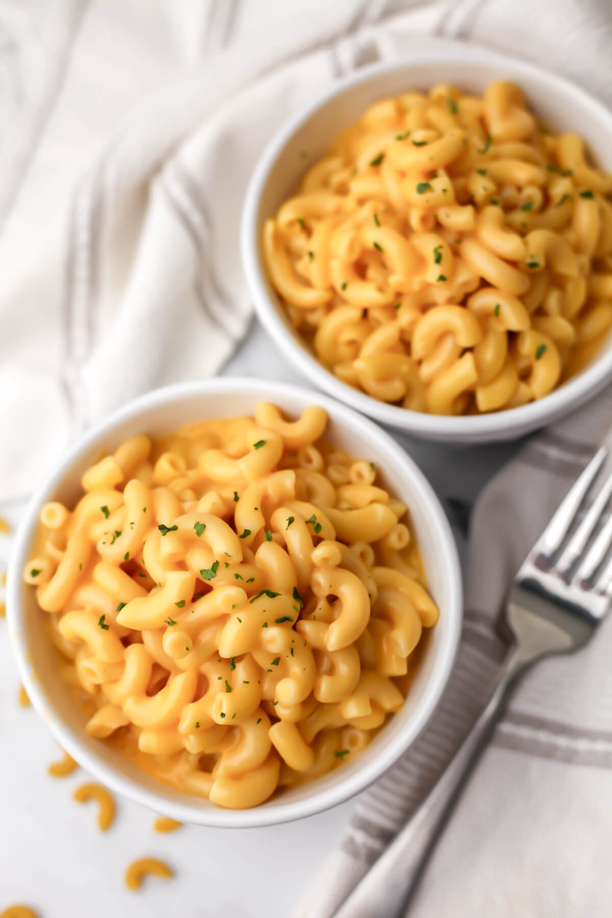 A top view of 2 bowls of easy vegan mac and cheese made without nutritional yeast. 