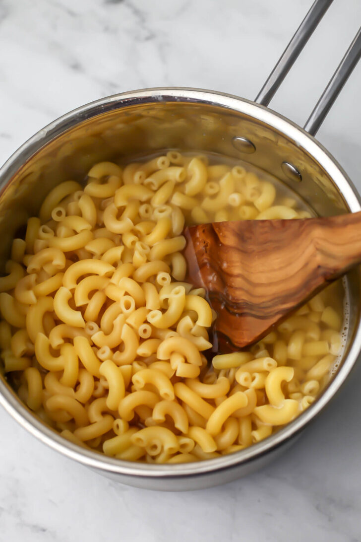 Macaroni cooked in water in a small pot.