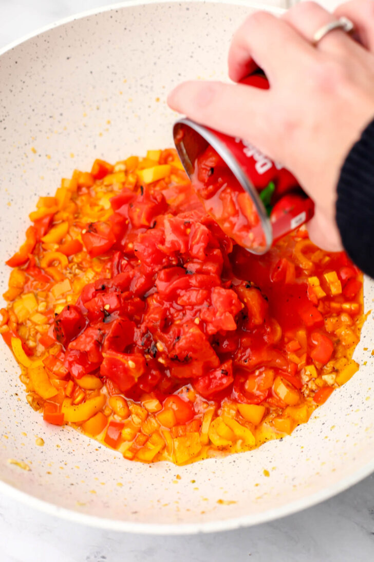 Fire roasted tomatoes added to sautéed garlic and peppers.