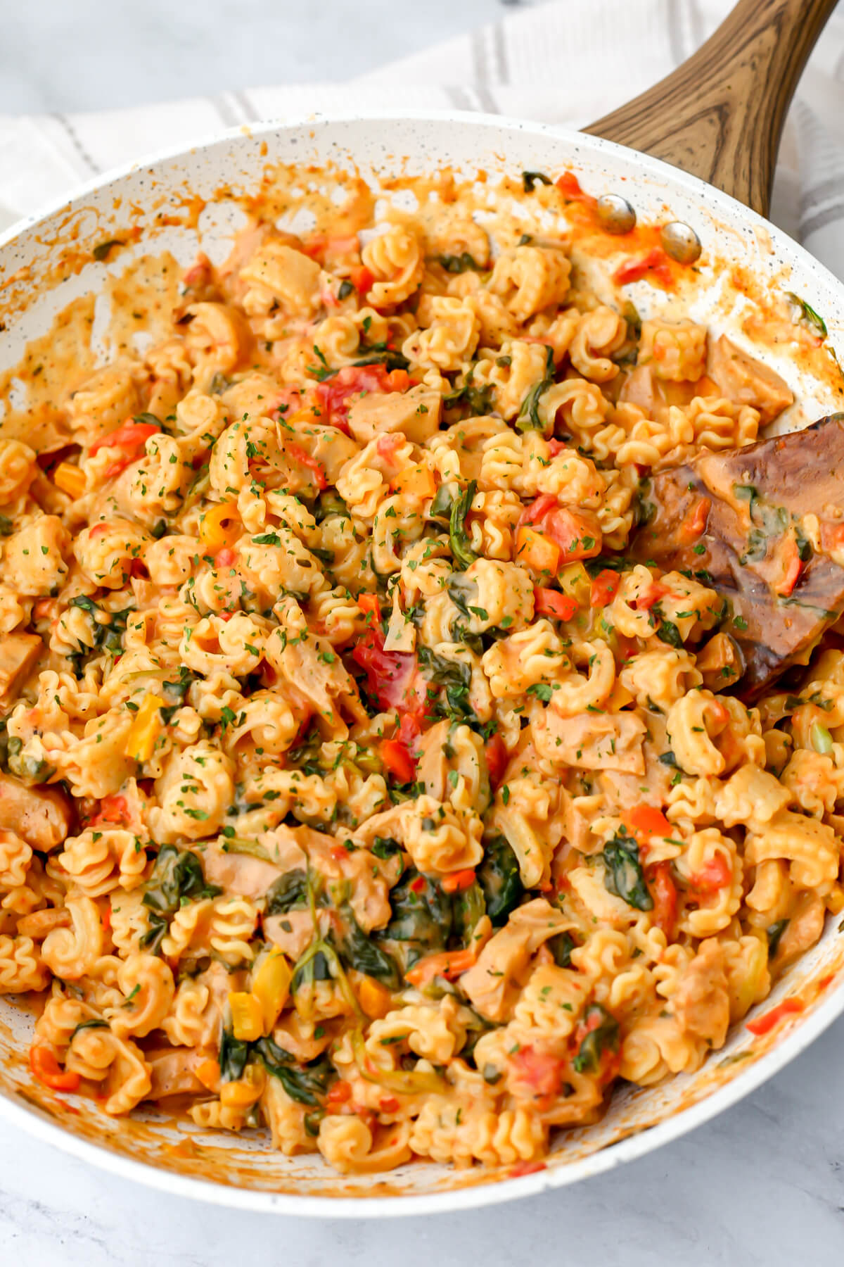 A top view of a skillet filled with creamy vegan Cajun pasta with vegan chicken.