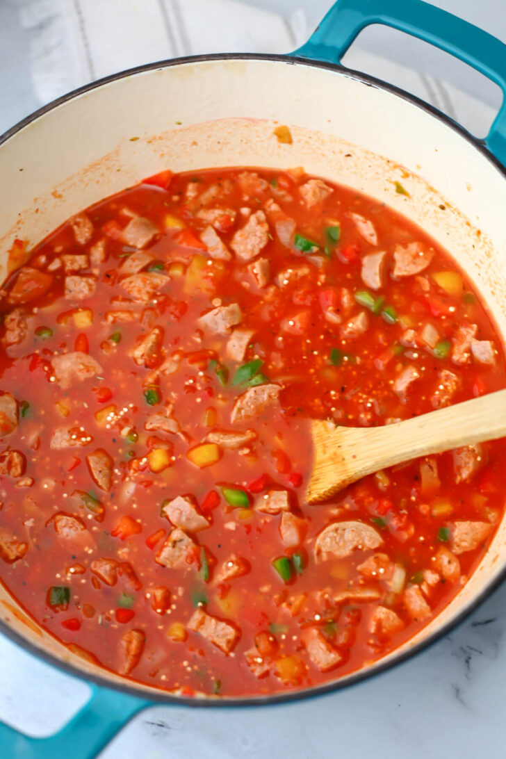 Pasta sauce and water added to a pot of stuffed pepper soup.