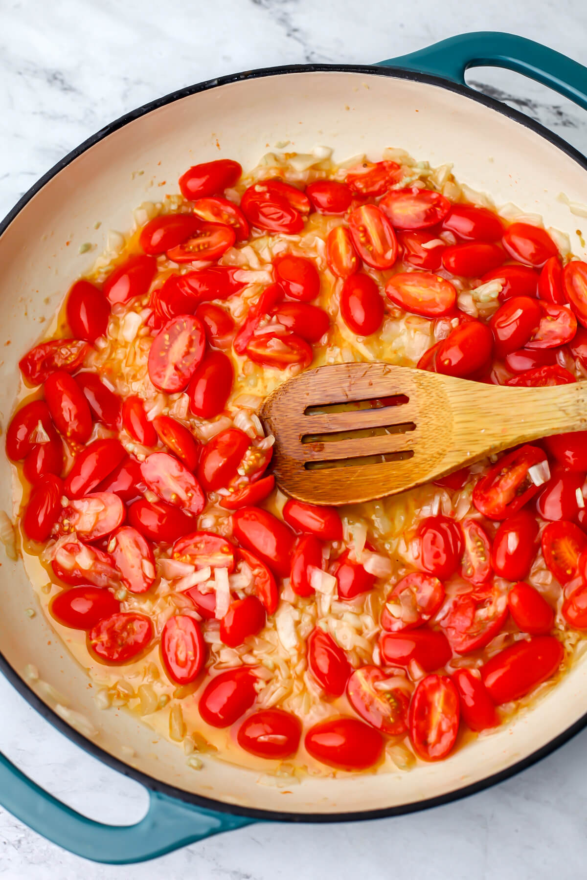 Cherry tomatoes cut in half and added to onions and garlic sauteing in olive oil.