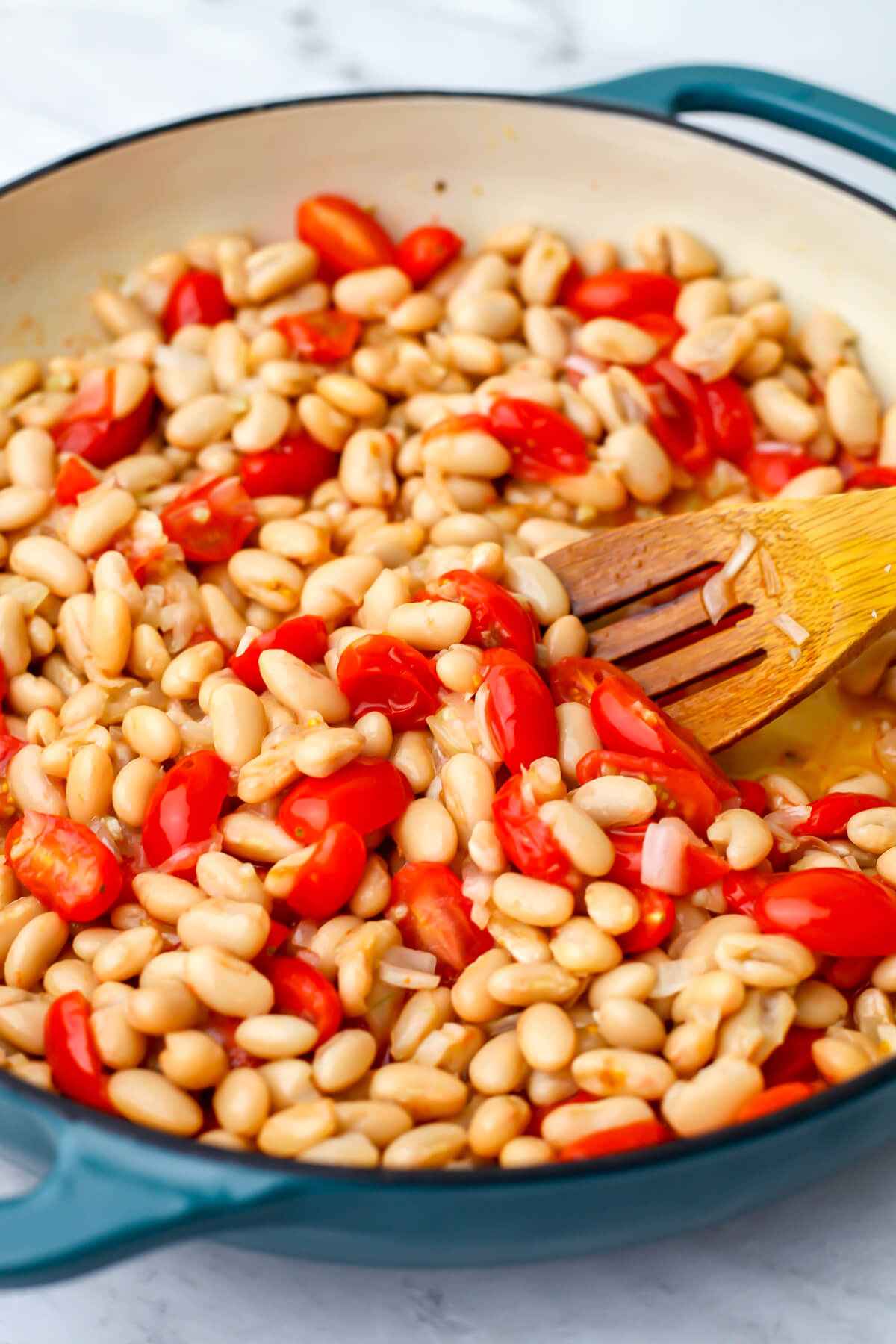 White beans added to cherry tomatoes cooked in olive oil, onions, and garlic.
