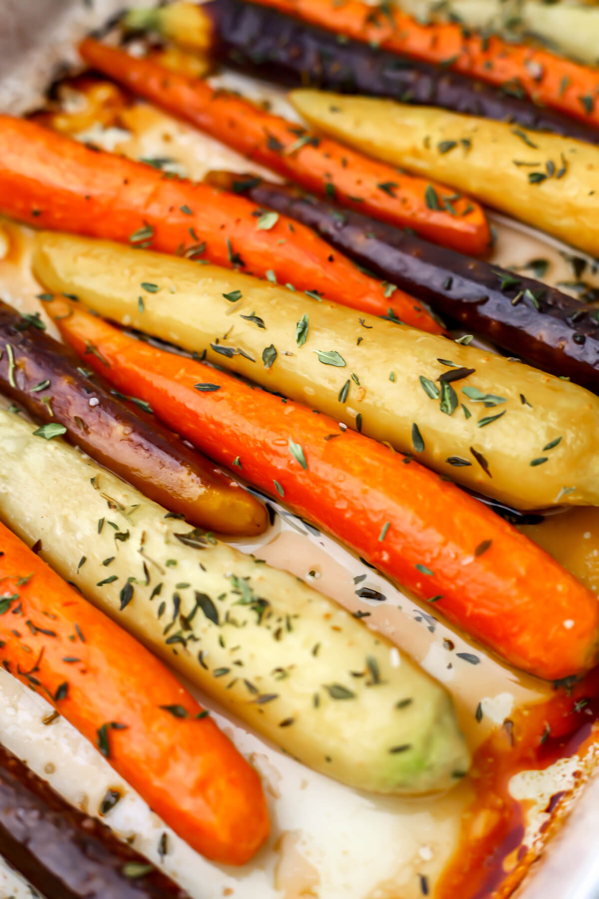 Roasted rainbow carrots in a white casserole dish.