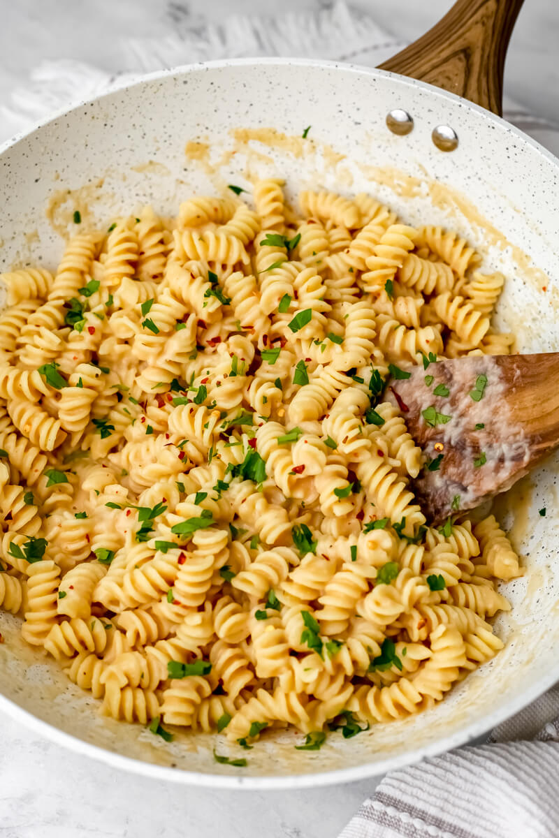 Pasta tossed with white bean pasta sauce with parsley sprinkled on top.