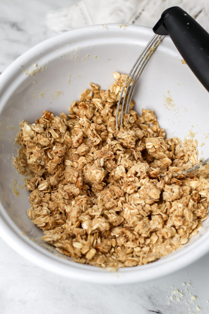 A vegan crumble topping mixed in a bowl before putting over top of fruit.
