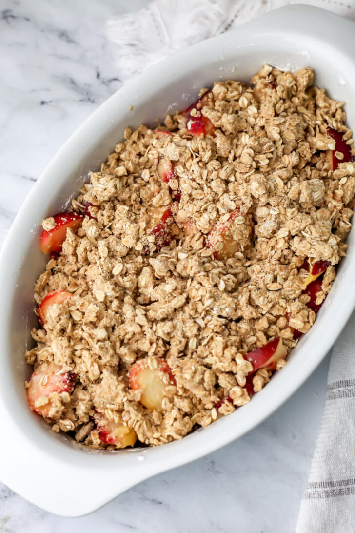 Crumble topping sprinkled over peaches before it has been baked.