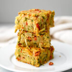 Three pieces of vegan zucchini slice on a white plate.