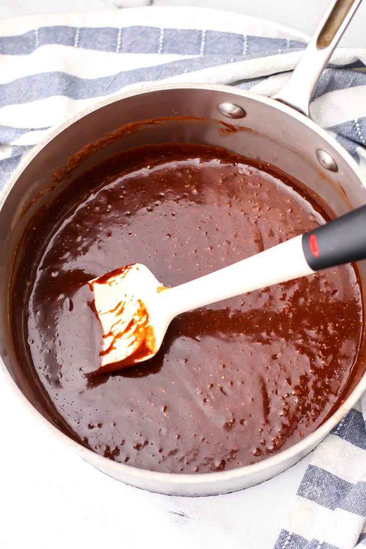 The chocolate almond butter mixture in a sauce pan before adding the oats to make almond butter no-bake cookies.