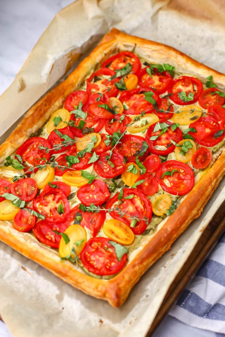 A baked vegan tomato tart on a baking sheet.