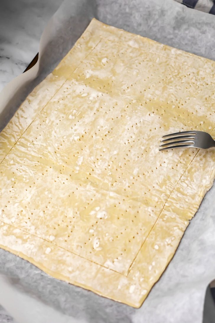 A puff pastry rolled out and scored around then edges then pricked with a fork in the middle.