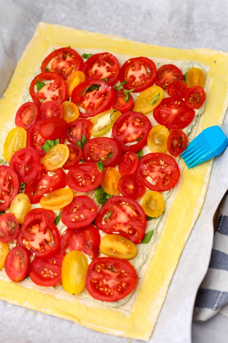 Brushing the edges of the puff pastry with vegan milk with a dash of turmeric in it.