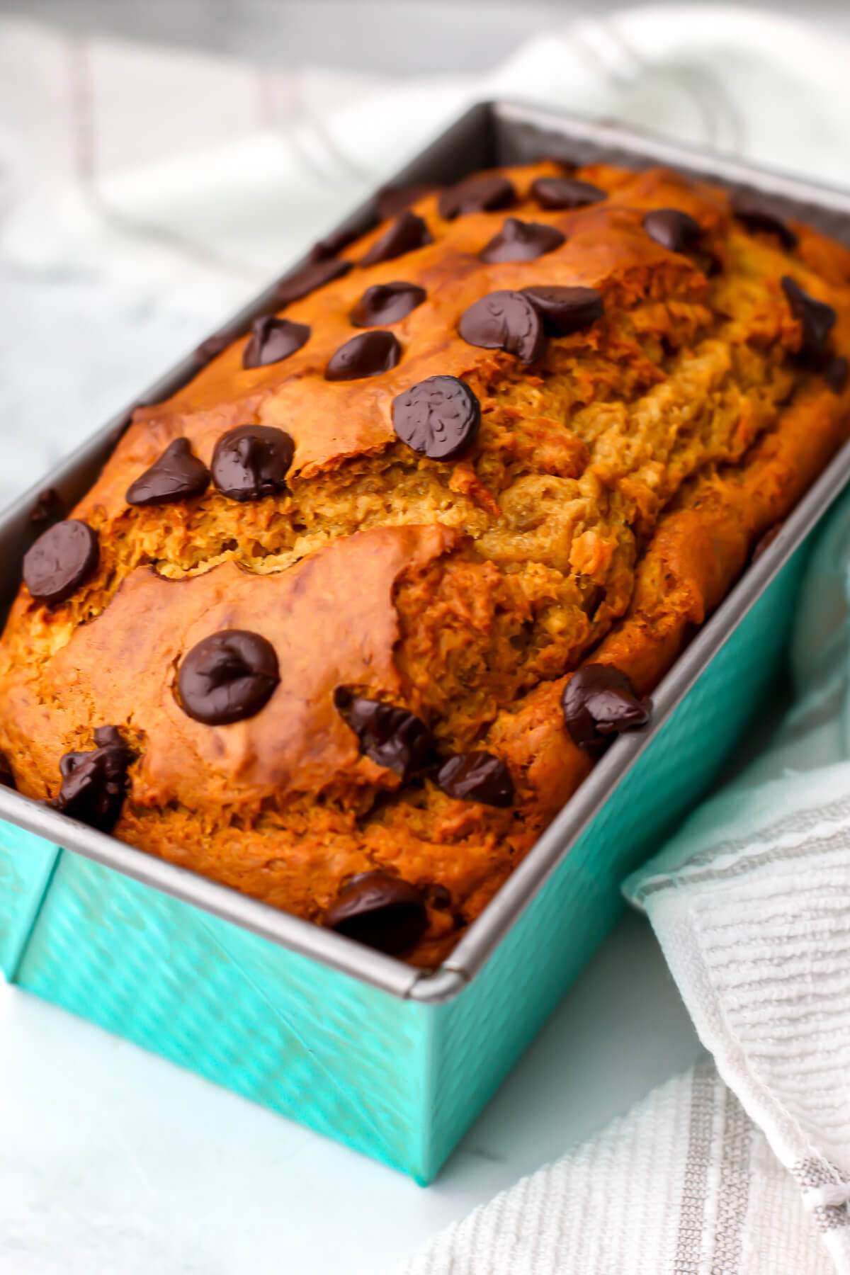A vegan banana pumpkin bread in a blue bread pan.