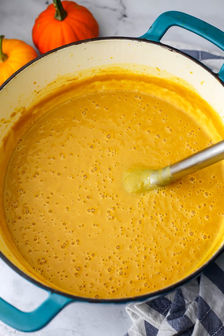 Pumpkin white bean soup after it has been blended with an immersion blend in the pot.