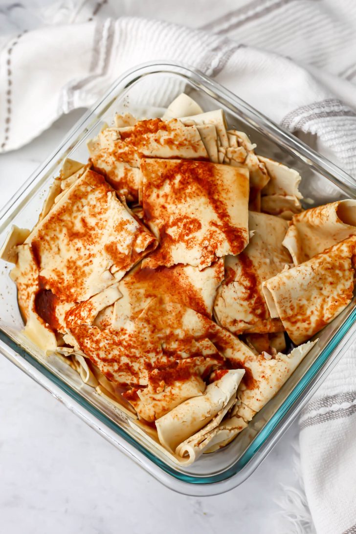 Marinade poured over shaved tofu in a glass contanier.