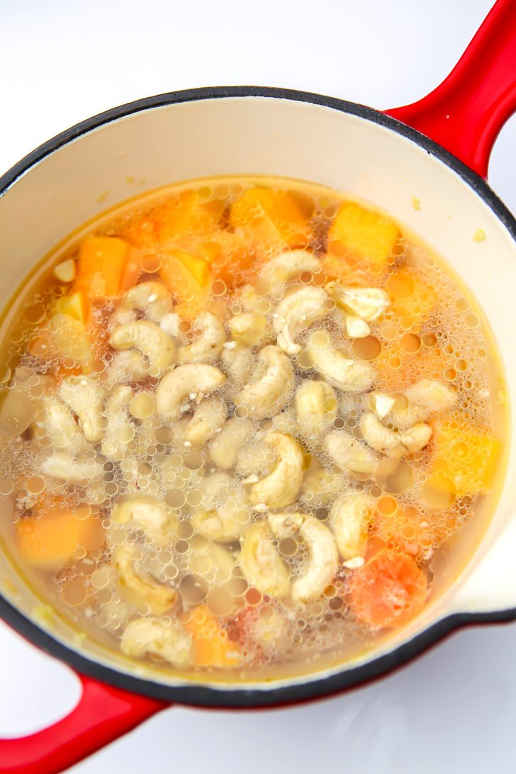 Veggie broth, cashews, and squash in a sauce pan to make veggies cheese sauce.