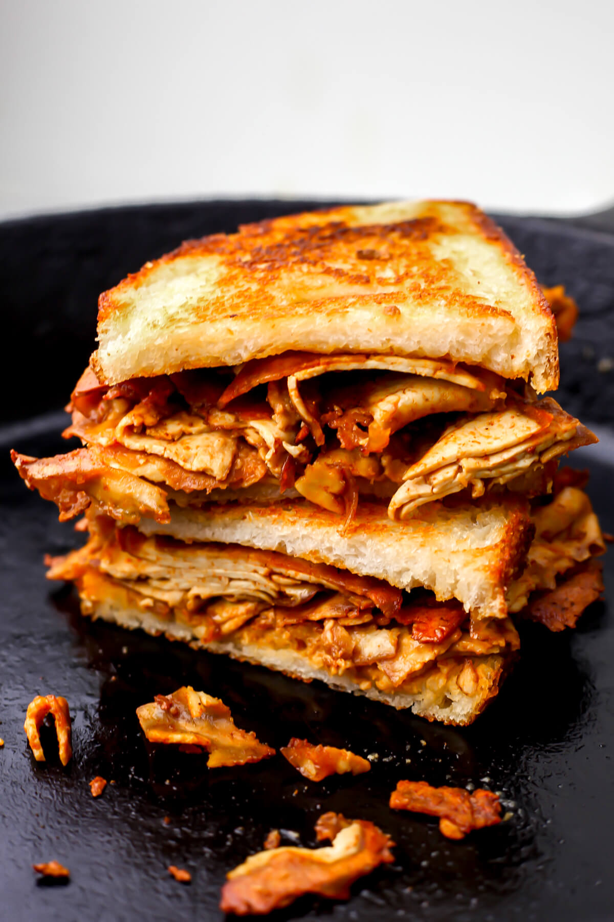 A grilled tofu sandwich in an iron skillet.