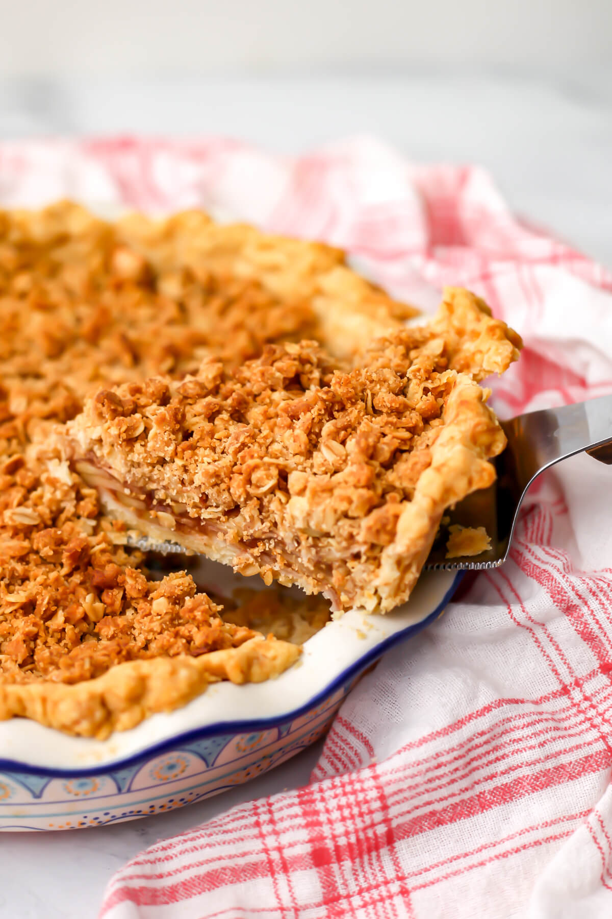 A vegan Dutch apple pie with a slice taken out of it.
